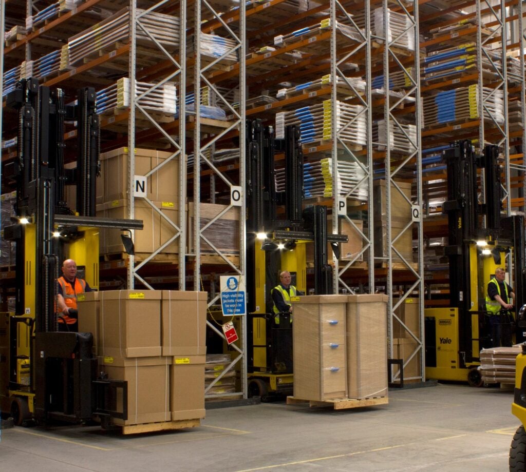 Yale Reach trucks operatings amongst tall, narrow-aisle racking systems in a warehouse.