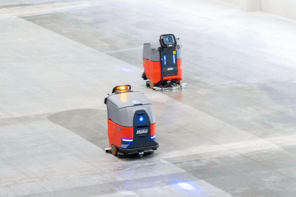 2 Hako Scrubmaster B75i autonomous floor cleaning machines working on a large floor