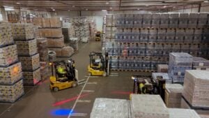 These three electric counterbalance forklifts stacking pallets in a warehouse were supplied by Briggs Equipment and are helping Whyte & Mackay achieve their sustainability goals.