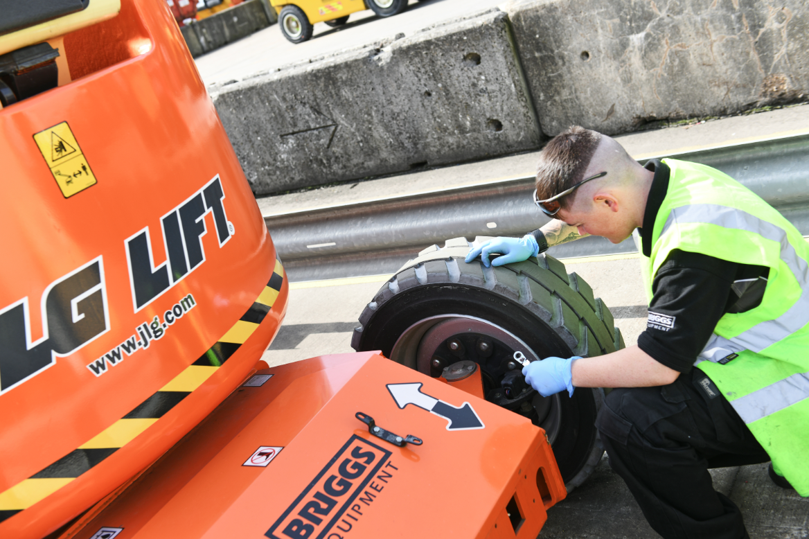 JLG Machine with a Briggs Equipment service engineer inspecting the tyre